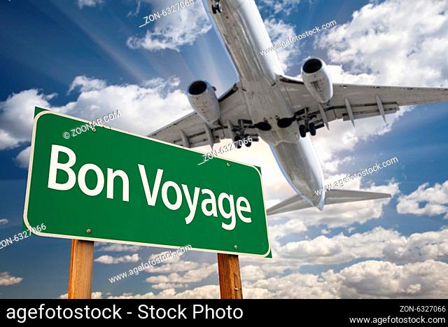 Bon Voyage Green Road Sign and Airplane Above with Dramatic Blue Sky and Clouds