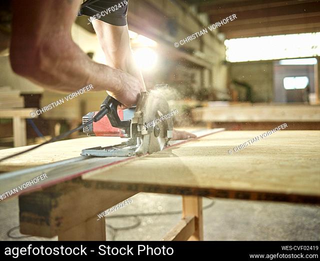 Carpenter cutting oriented strand board with circular saw