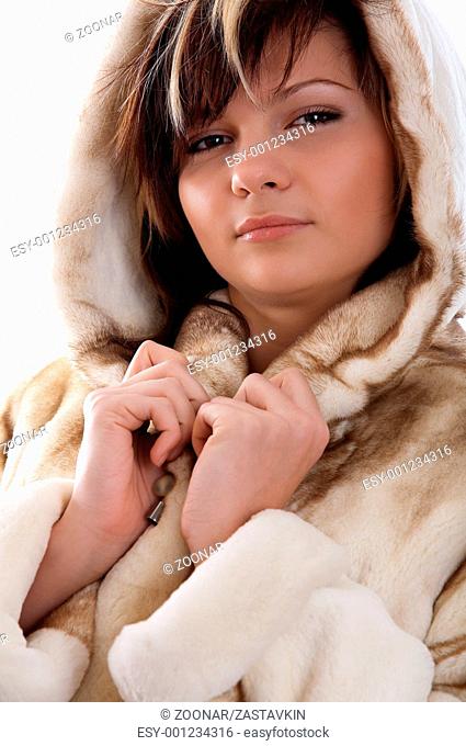 Girl in fur coat on white background