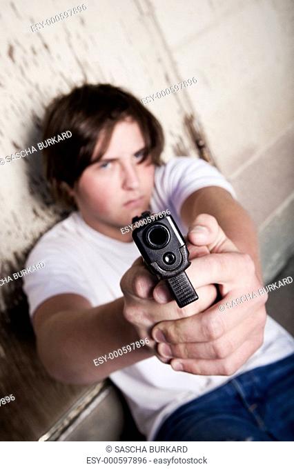 teen male aiming gun at camera