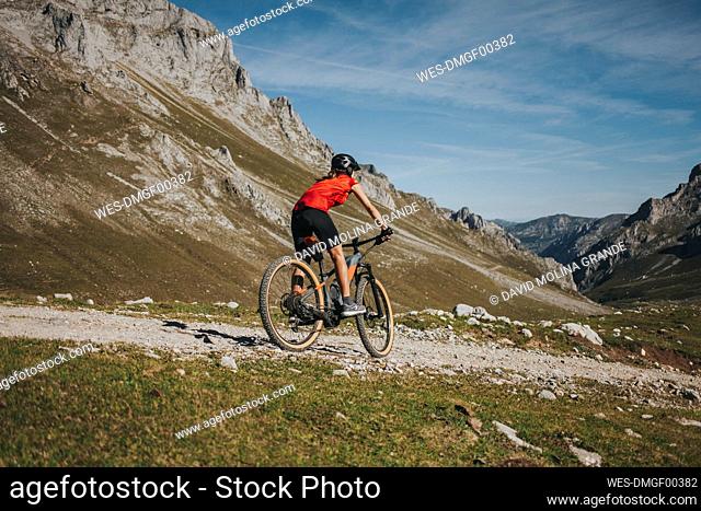 Female cyclist riding mountain bike at Picos de Europa National Park, Cantabria, Spain