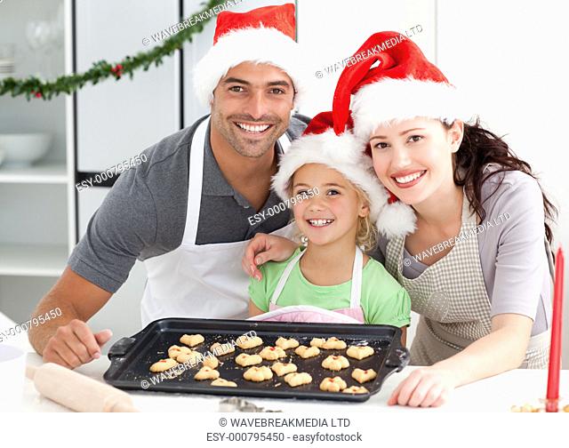 Happy woman with husband and daughter ith their biscuits ready to eat in the kitchen