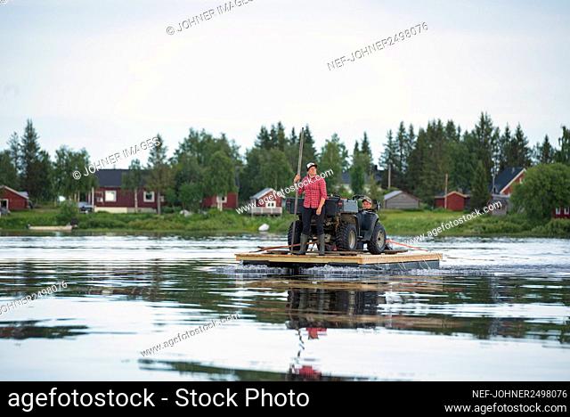 Couple transporting quadbike on motor raft