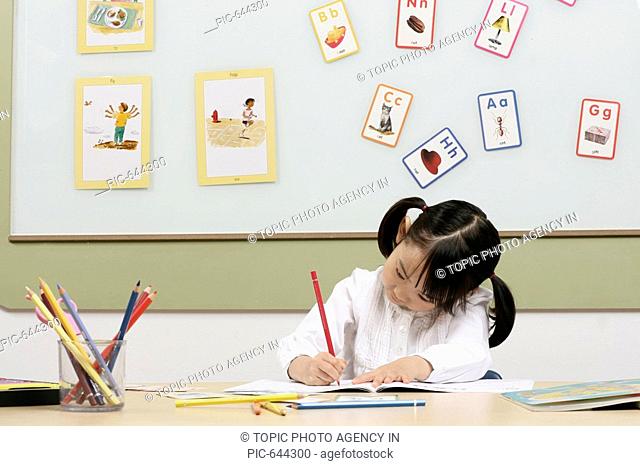 Korean Girl Drawing a Picture in the Kindergarten
