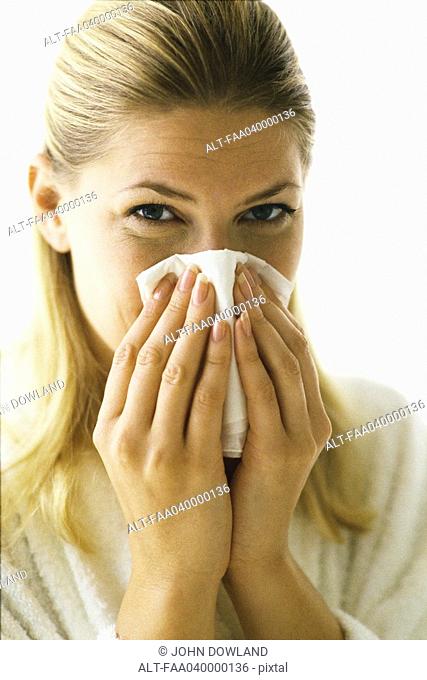 Woman blowing nose