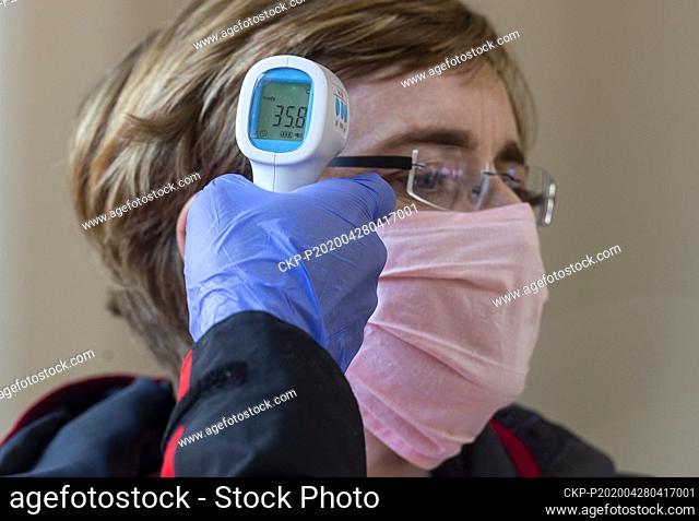 A medic measures temperature to a volunteer before taking a sample for a covid-19 test, on April 28, 2020, in Litomerice, Czech Republic