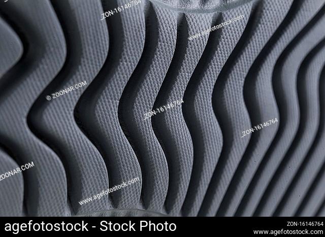 Fragment of a black sole of a sneaker. The texture of the material of sports shoes