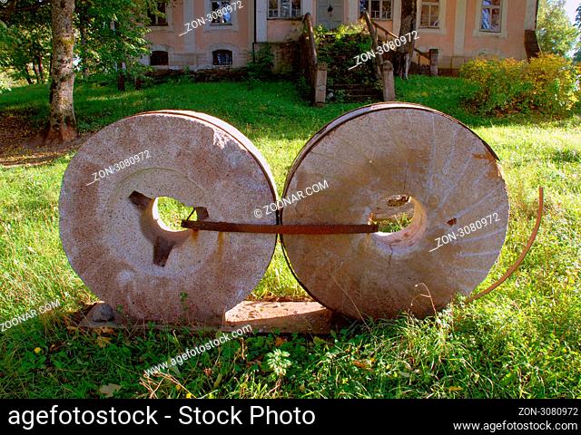 Two antique millstones decorates old house environment