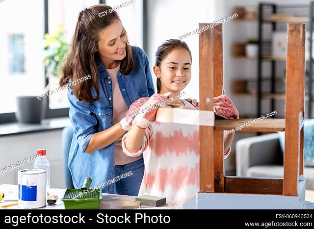 mother and daughter sticking masking tape to table