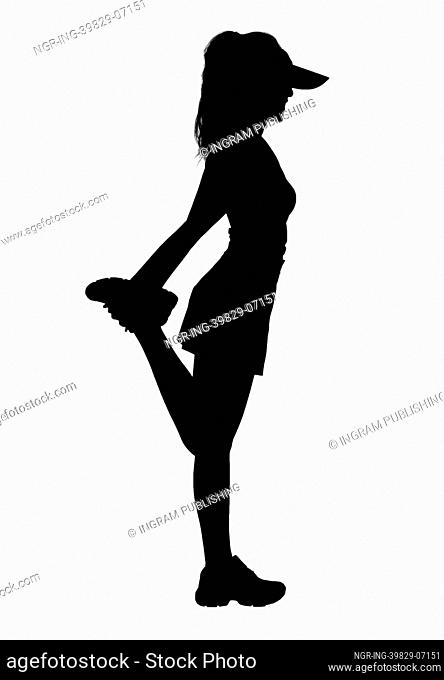 Silhouette of woman stretching leg