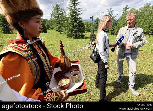 RUSSIA, ALTAI REPUBLIC - JUNE 22, 2023: A woman in traditional clothes and Sberbank CEO Gref (R back) are seen during a guided eco trail tourin Manzherok resort...