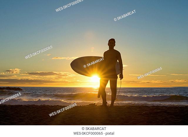 Surfer at sunrise on the beach