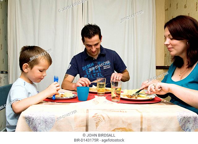Polish family sitting around table eating dinner