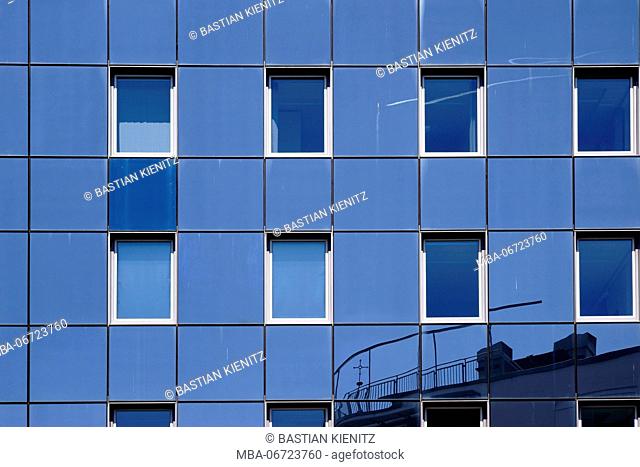 The reflexion of buildings in the modern facade of an office building and residential house