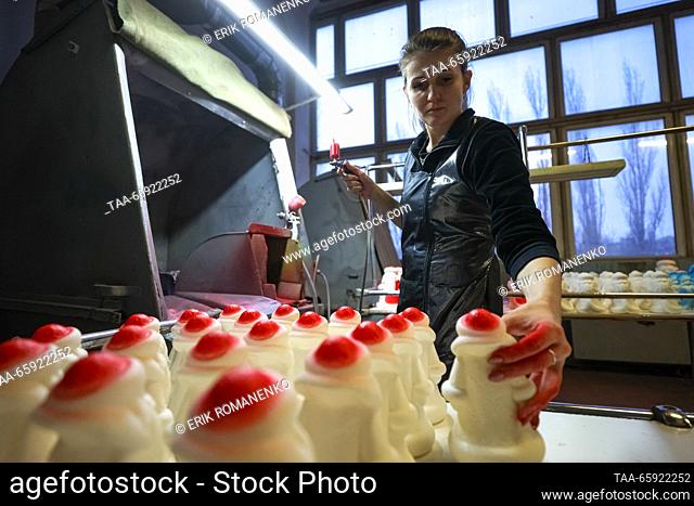 RUSSIA, VORONEZH - DECEMBER 19, 2023: An employee spray paints a Christmas ornament at the Igrushki toy factory. The enterprise is engaged in production of PVC...