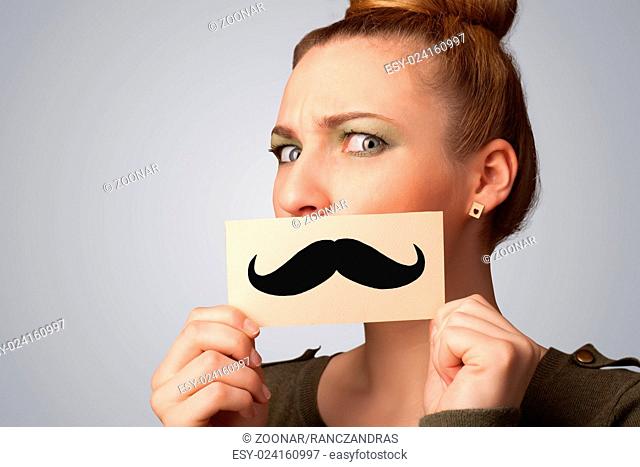 Happy cute girl holding paper with mustache drawing