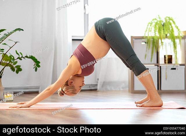 happy pregnant woman doing yoga at home