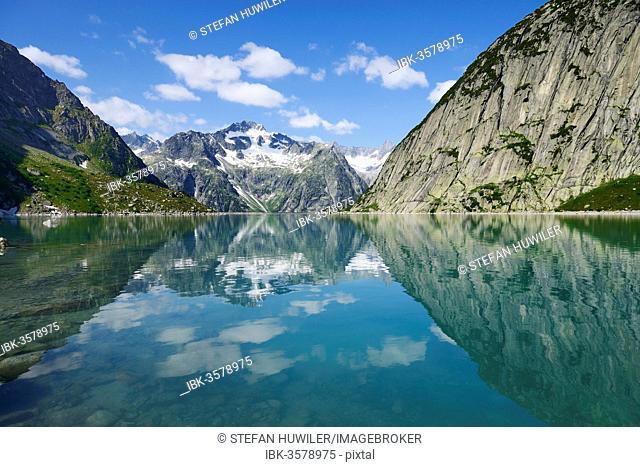 Mountains around the Grimsel Pass are reflected in Gelmerstausee reservoir, Guttannen, Canton of Bern, Switzerland