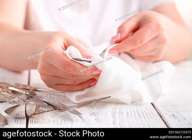 Female hand cleaning spotty silverware with a cleaning product and a cloth, Close up woman hand cleaning silver spoon, polished silver
