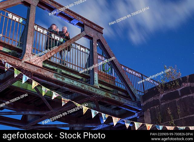 09 September 2022, Saxony-Anhalt, Magdeburg: Two festival visitors stand on the historic lift bridge, a landmark of the city of Magdeburg