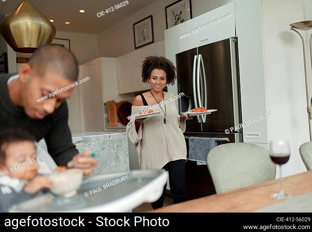 Woman carrying plates of spaghetti to dining table