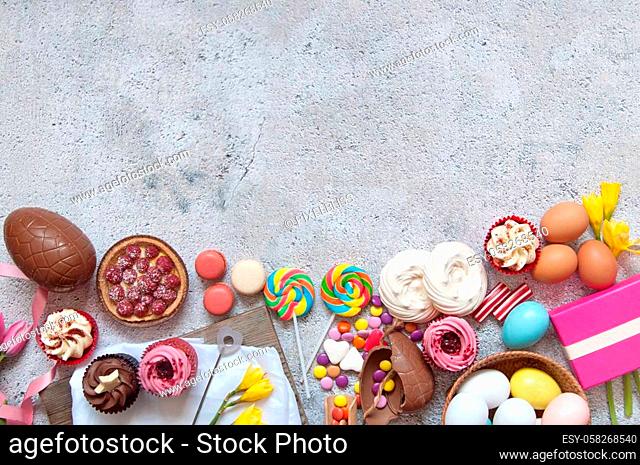 Assorted easter sweets, bakery cupcakes, chocolate eggs and confectionery with space