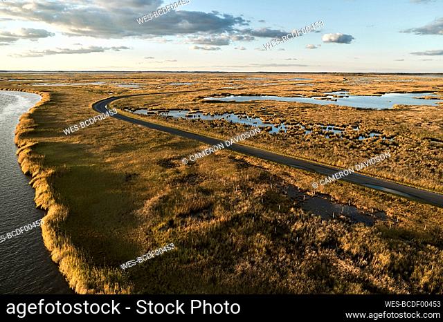 USA, Maryland, Drone view of road stretching across marshes along Blackwater River at dusk