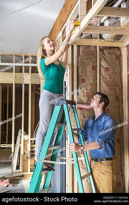 Caucasian couple working at construction site