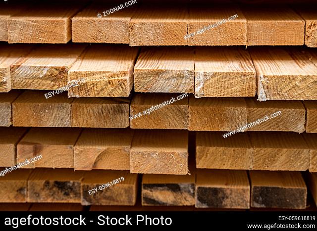 Piles of wooden boards in the sawmill, planking. Warehouse for sawing boards on a sawmill outdoors. Wood timber stack of wooden blanks construction material