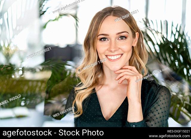 Beautiful businesswoman with hand on chin in office