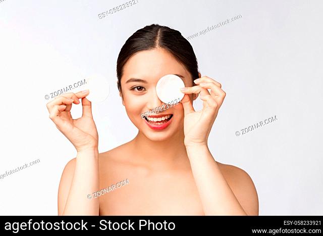 skin care woman removing face makeup with cotton swab pad - skin care concept. Facial closeup of beautiful mixed race model with perfect skin