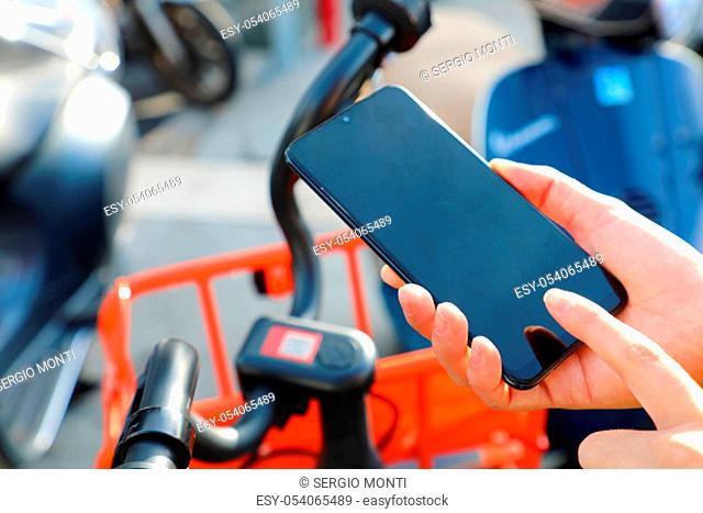 Shared bikes. Hand using smartphone scanning the QR code of shared bike in city