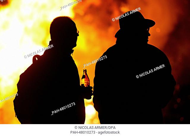Two men are silhouetted against an Easter Fire in Schoeffelding, Germany, 19 April 2014. Photo: NICOLAS ARMER/dpa | usage worldwide