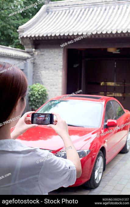 Young Woman Taking a Picture of Her Car