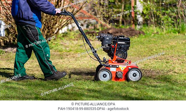 17 April 2019, Lower Saxony, Rehlingen: An employee mows the lawn with a lawn mower on the grounds of the SOS Children's Village in Bockum