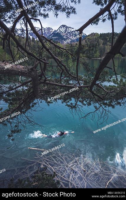 Professional triathlete swimming, training in a clear mountain lake in Allgäu, Alatsee, Bavaria, Germany
