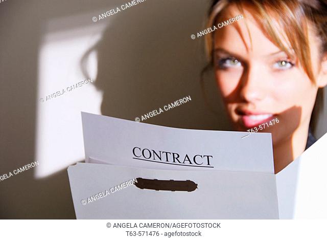 20 yr old young woman holding file folder contract papers