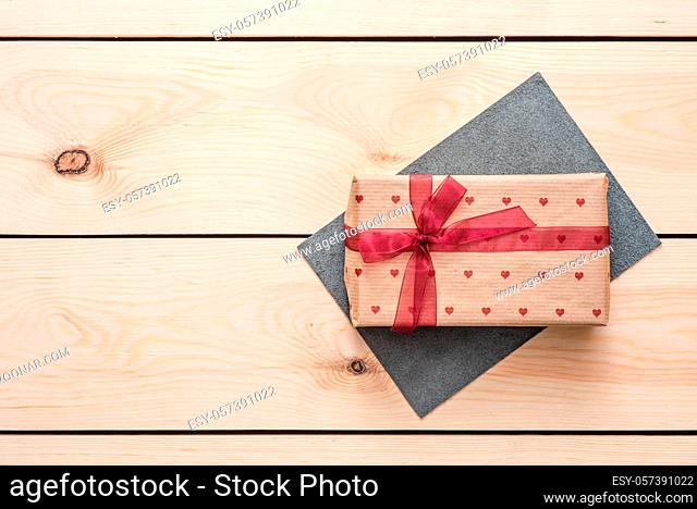 Gift box on wooden desktop. Top view