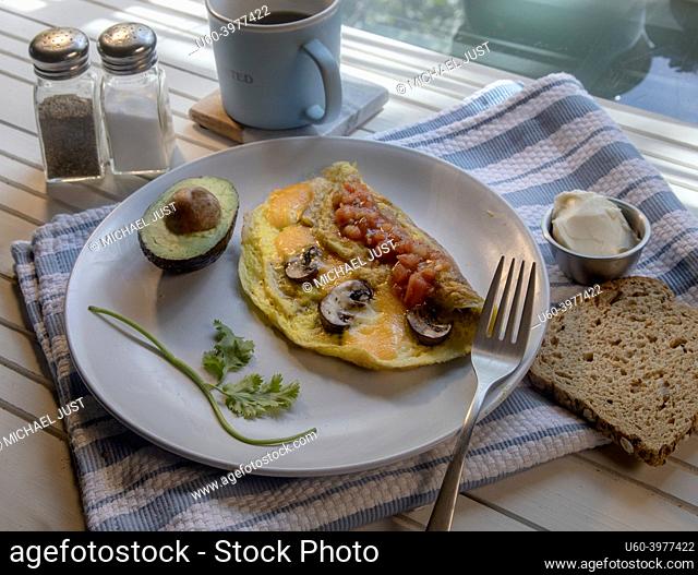 Top View of mushroom and cheese omelette on white natural wood table