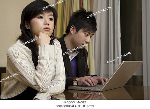Man ignoring girlfriend for laptop