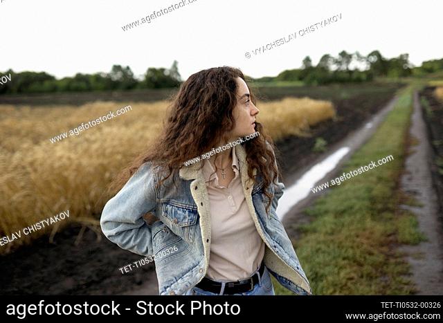 Russia, Omsk, Young woman standing in field