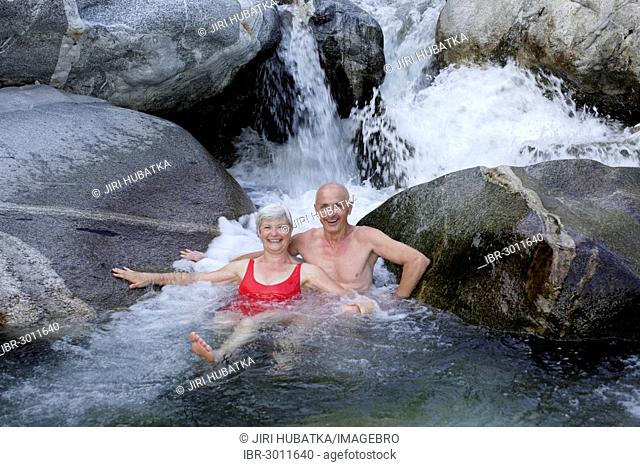 Couple, 59 and 68 years, bathing in the mountain river of Torrente Codera