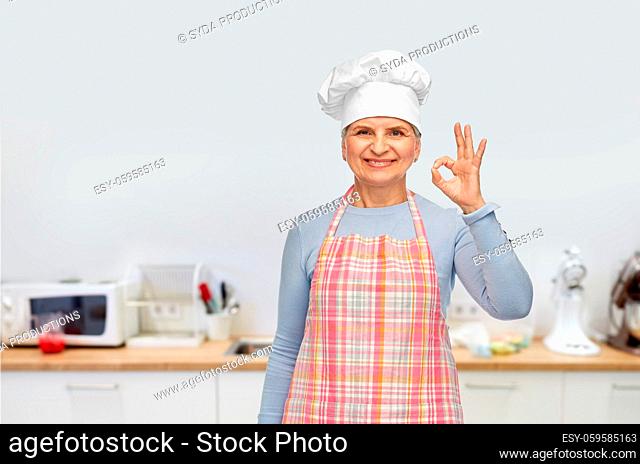 senior woman or chef in toque showing ok hand sign