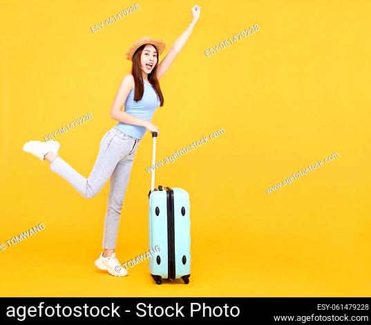 Happy young woman with luggage isolated on yellow background , summer, travel concept