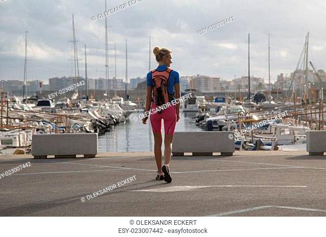 Young woman walking with her back bag in harbor