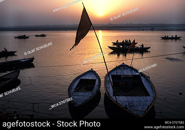 Varanasi, Uttar Pradesh, India, Asia - Daybreak with sunrise over wooden rowboats at a ghat on the bank along the holy Ganges River
