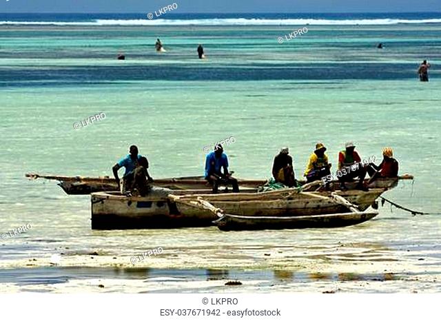 beach seaweed people and boat in tanzania zanzibar