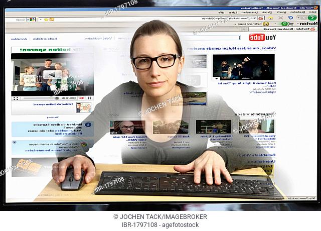 Young woman sitting at a computer surfing the Internet, viewing a video on the YouTube site, view from within the computer, symbolic image