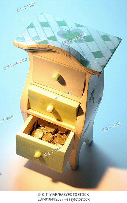 Coins in miniature chest of drawers