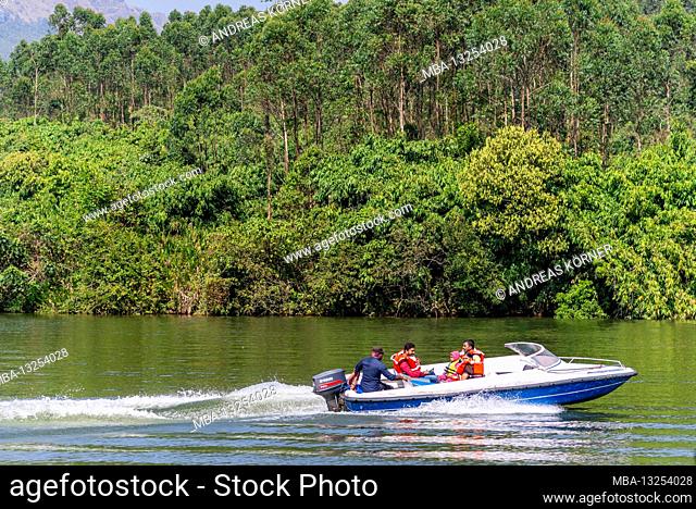 Motorboat drives over lake, jungle